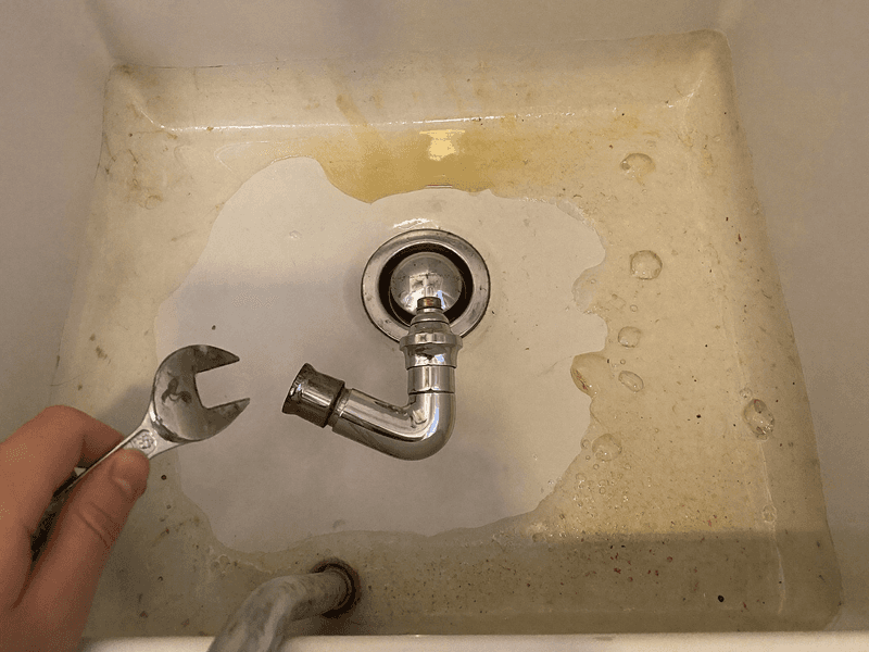 A newly fitted tap connector under a kitchen sink